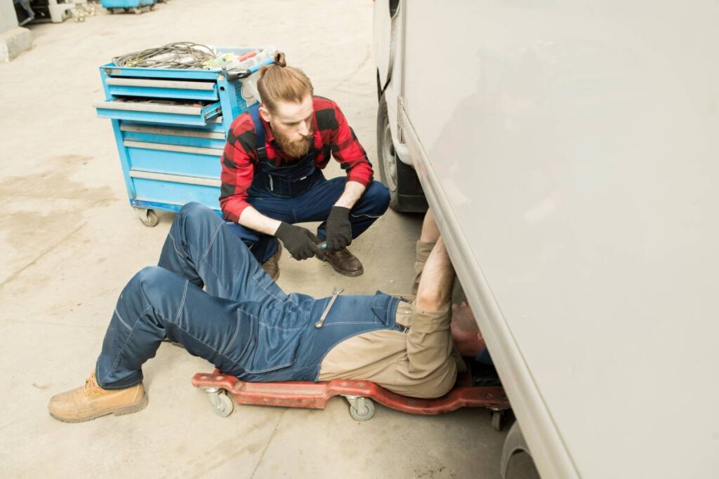 Person inspecting caravan undercarriage
